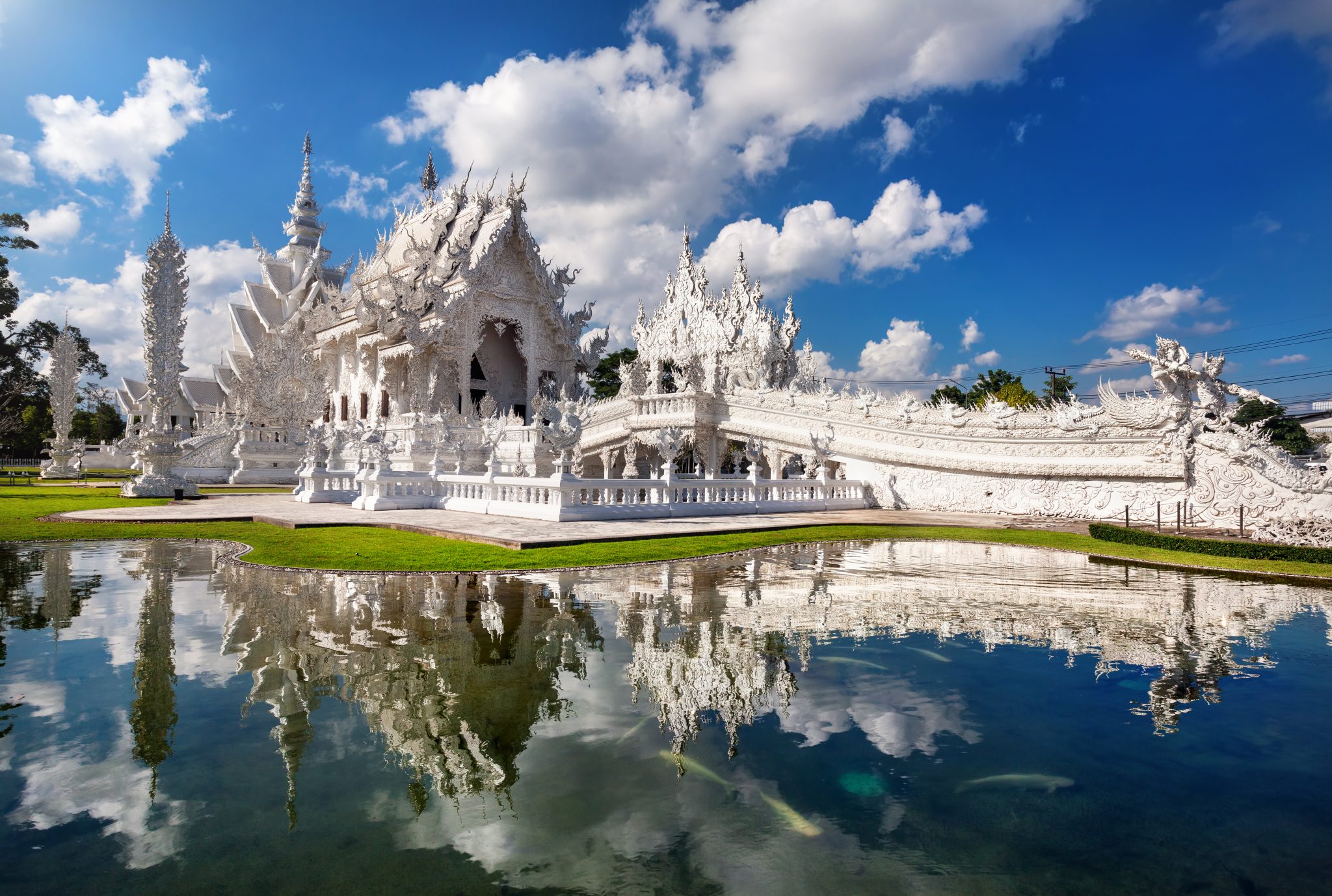 White Wat Rong Khun pagoda in front of lake in Chiang Rai Province, Thailand