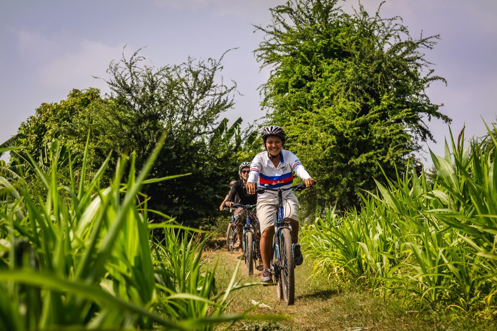 Local guide leading cyclists through countryside on Silk Islands