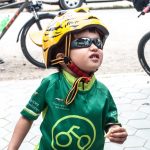 Small child in helmet and Grasshopper Adventures cycling jersey