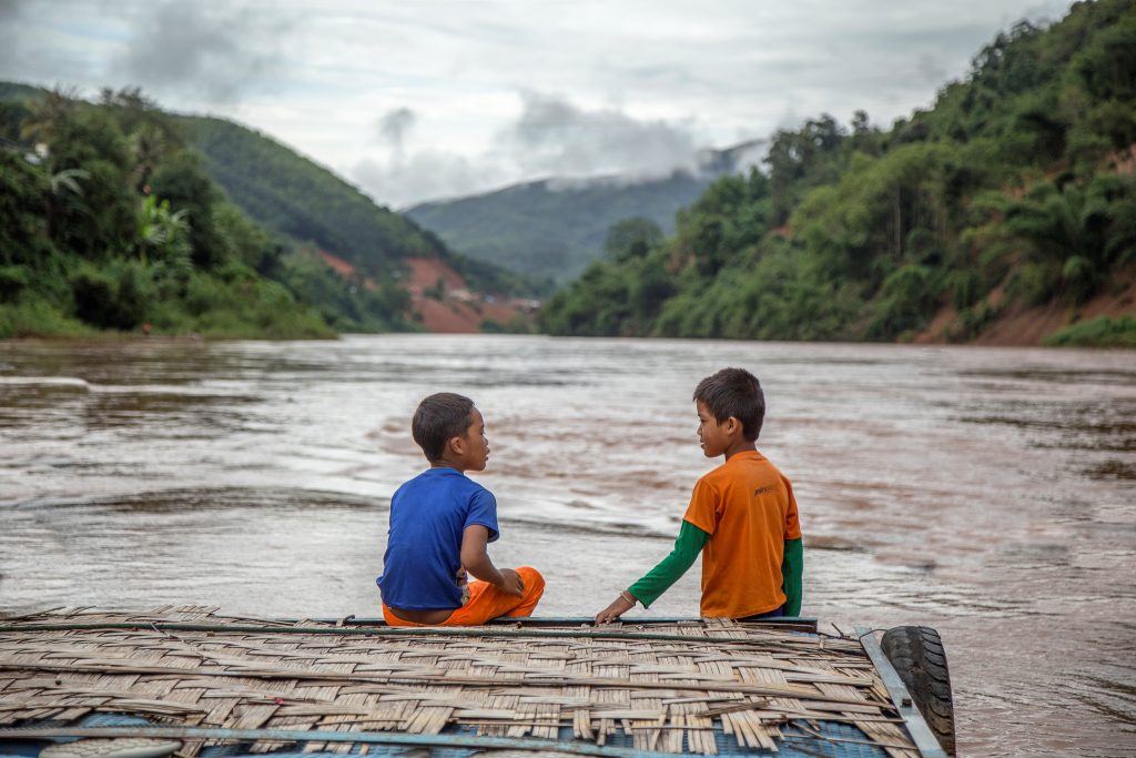 Two young children on boat on river in Laos