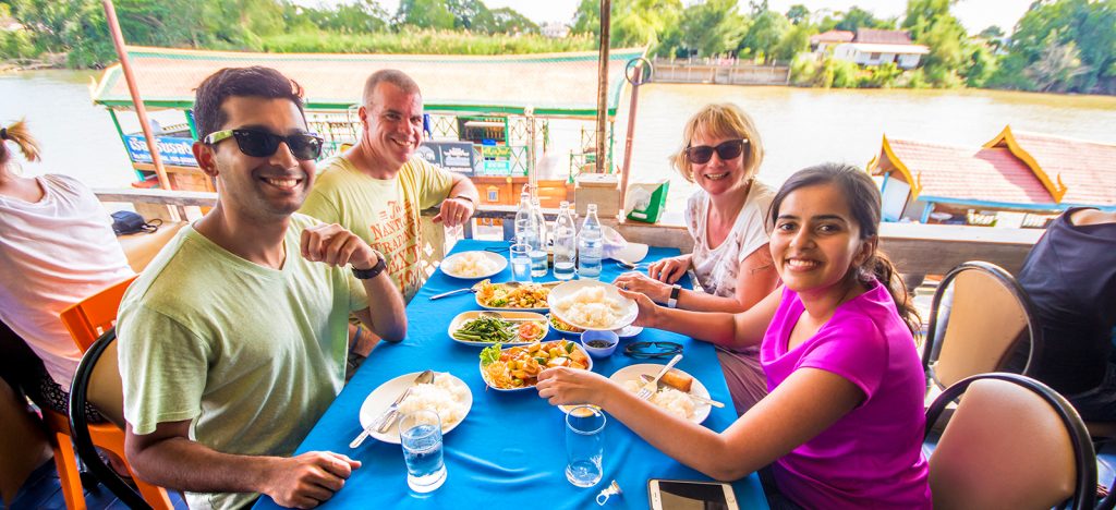 Four people eating traditional Thai meal