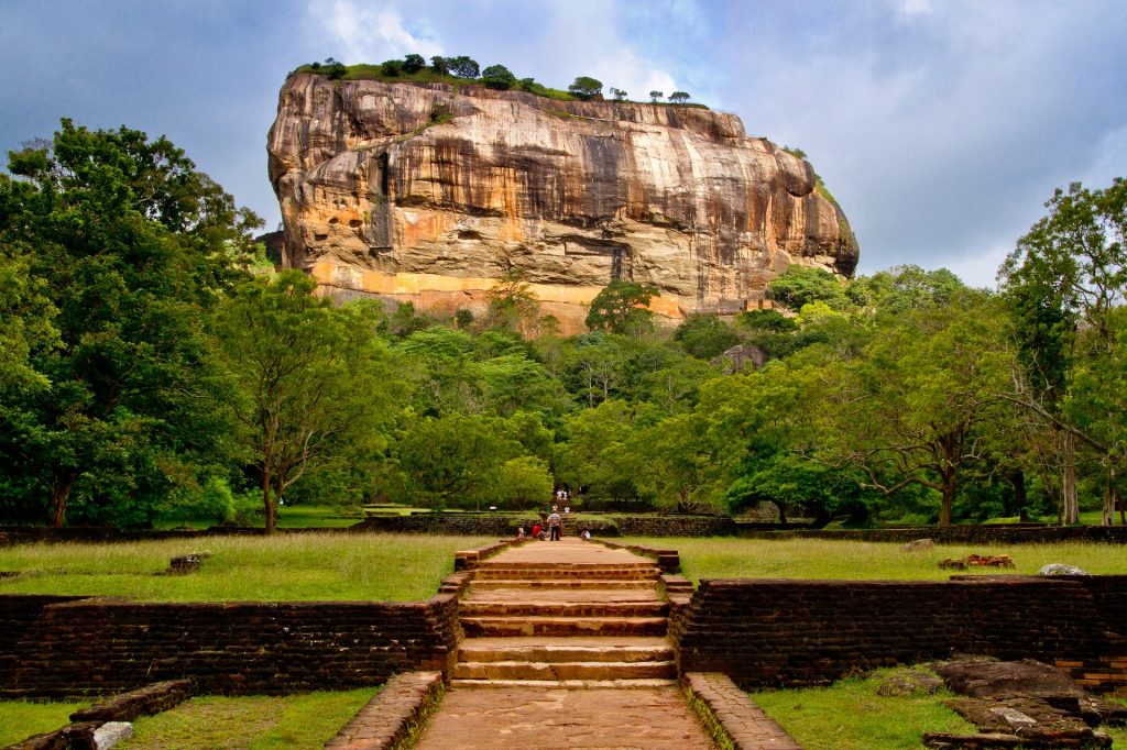 Sigiriya rock behind trees and stairs