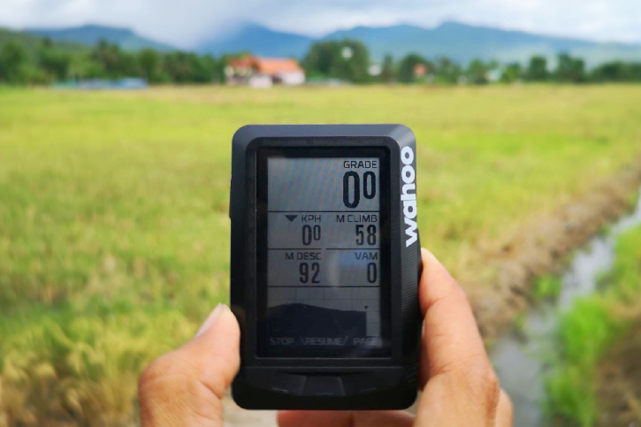 Wahoo ELEMNT device against a countryside background and hills on the horizon.