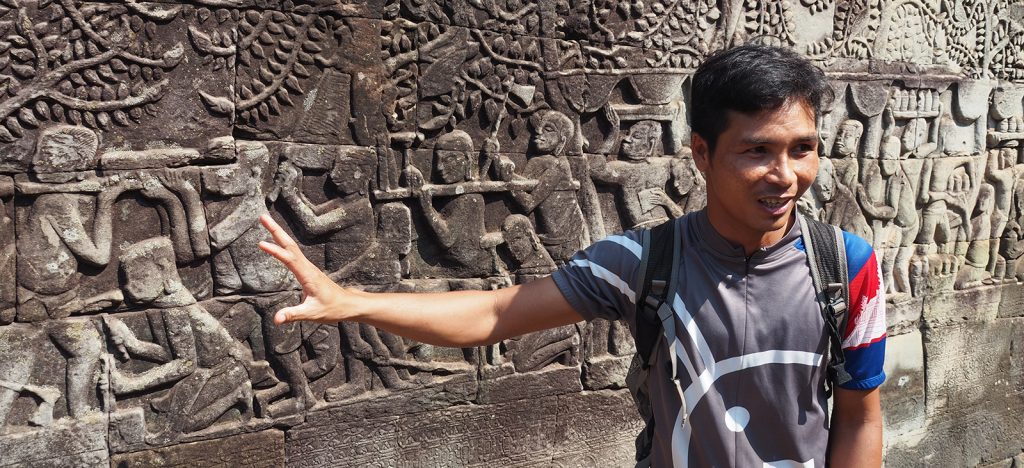 Cambodian guide showing the murals of Angkor Wat
