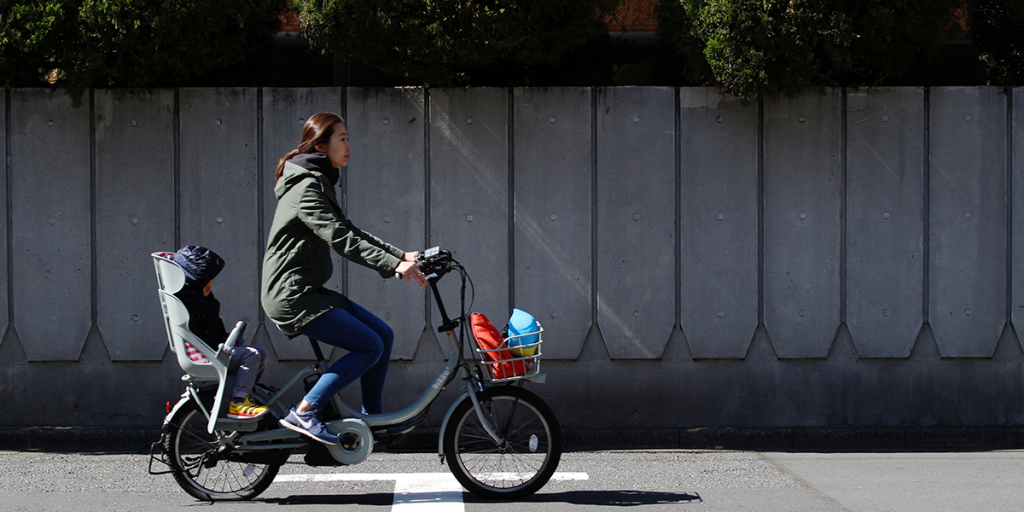 Woman riding e-bike on a street in Japan