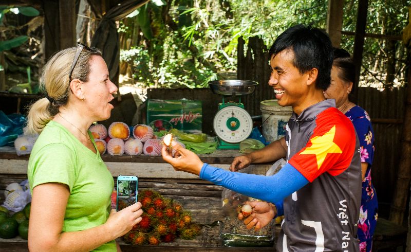 Guide and guest taste tropical fruit in Vietnam